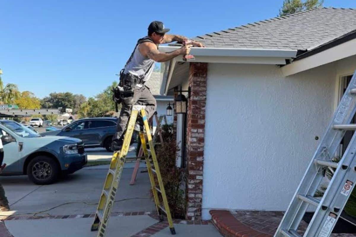 Technician from A1 Oasis Construction installing a gutter drain system during a gutter repair job in New Jersey.